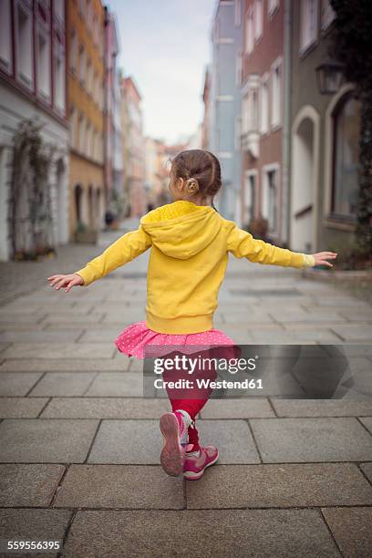 germany, bavaria, little girl dancing in an alley - bavaria girl stock pictures, royalty-free photos & images