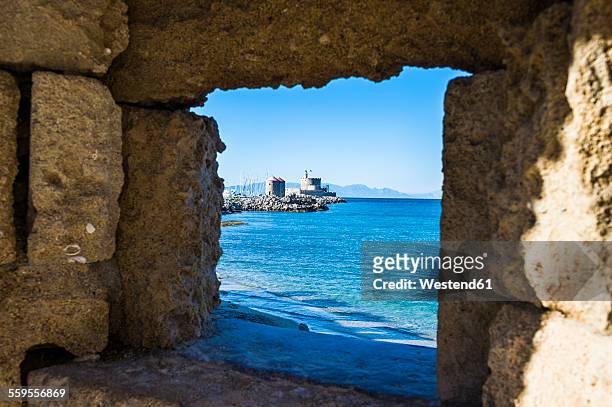 greece, rhodes, view through a window at the coast to the okld town - rhodes,_new_south_wales stock pictures, royalty-free photos & images