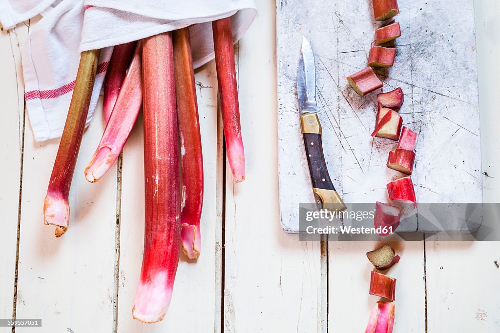 Rhubarb stalks, cut in pieces, board and knife
