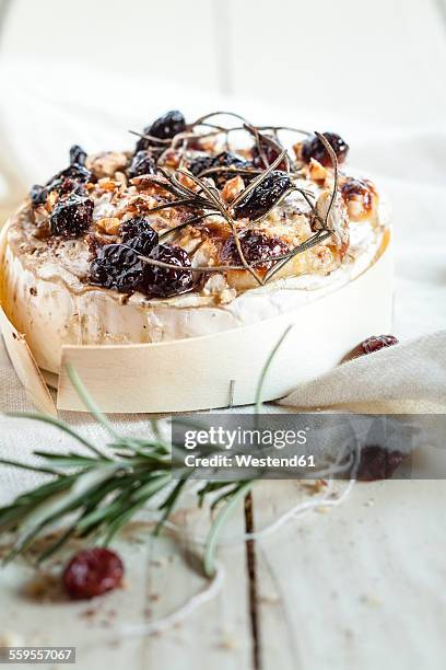 baked camembert with rosemary, nuts, cranberries and honey - camembert stock-fotos und bilder