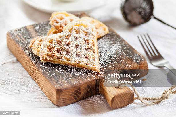 heart-shaped waffles on cutting board - waffle stock-fotos und bilder
