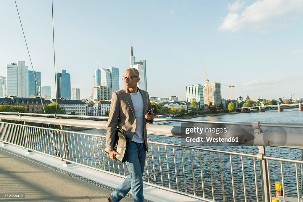 Germany, Frankfurt, businessman walking on bridge