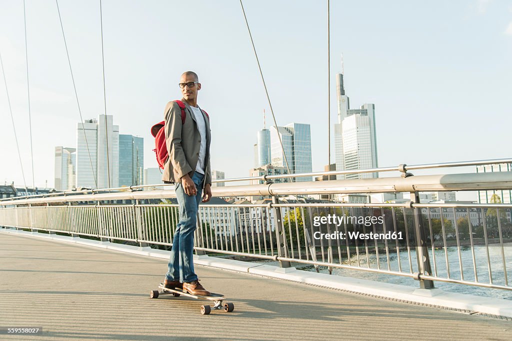 Germany, Frankfurt, man skateboarding on bridge