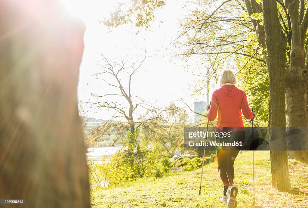 Germany, Mannheim, Mature woman Nordic walking in the park