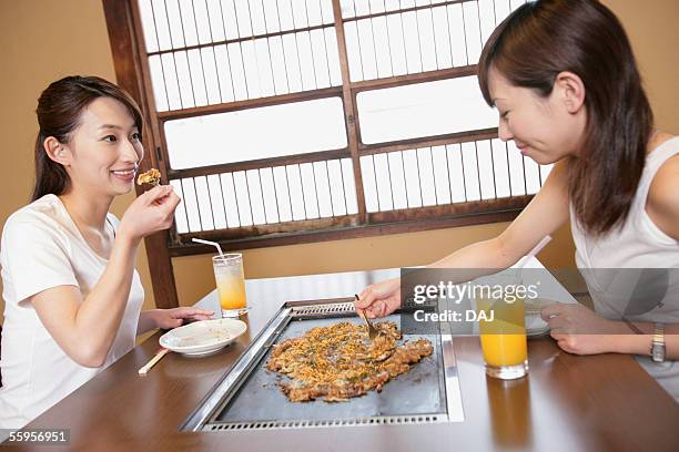 young women having japanese food, monjayaki - okonomiyaki stock pictures, royalty-free photos & images