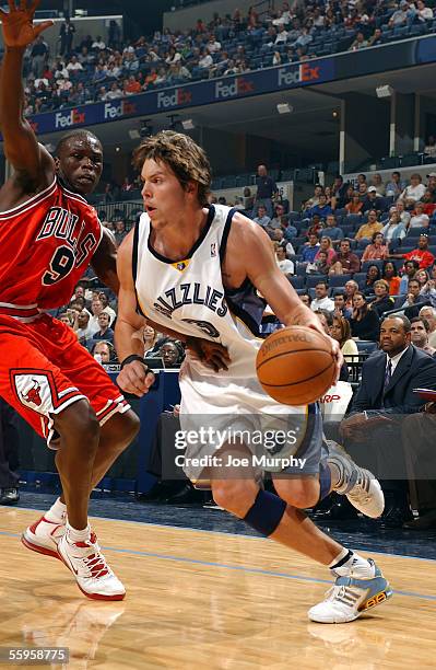 Mike Miller of the Memphis Grizzlies drives on Luol Deng of the Chicago Bulls during a preseason game on October 12, 2005 at FedexForum in Memphis,...