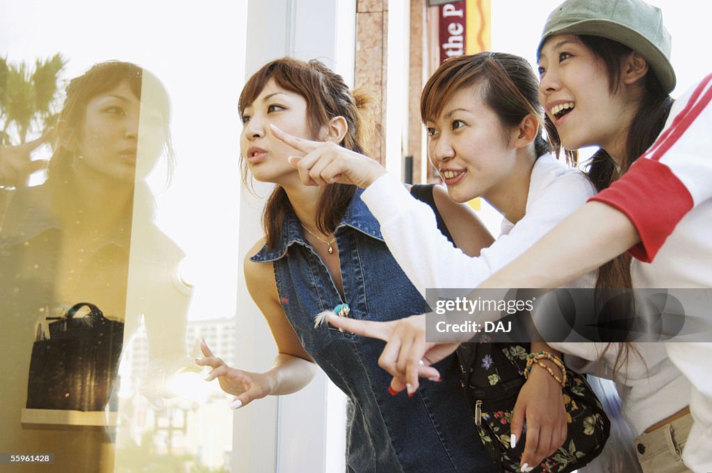 Young women looking in the shop window