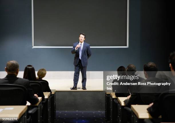 businessman talking in auditorium - auditorium stock pictures, royalty-free photos & images