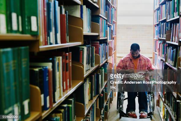 Male college student in wheelchair at library