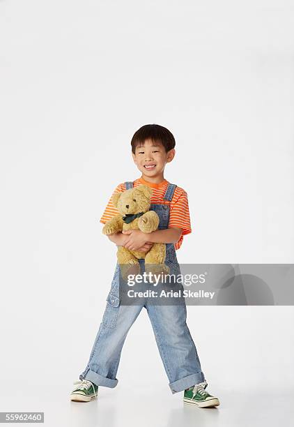 boy holding teddy bear - peluche foto e immagini stock