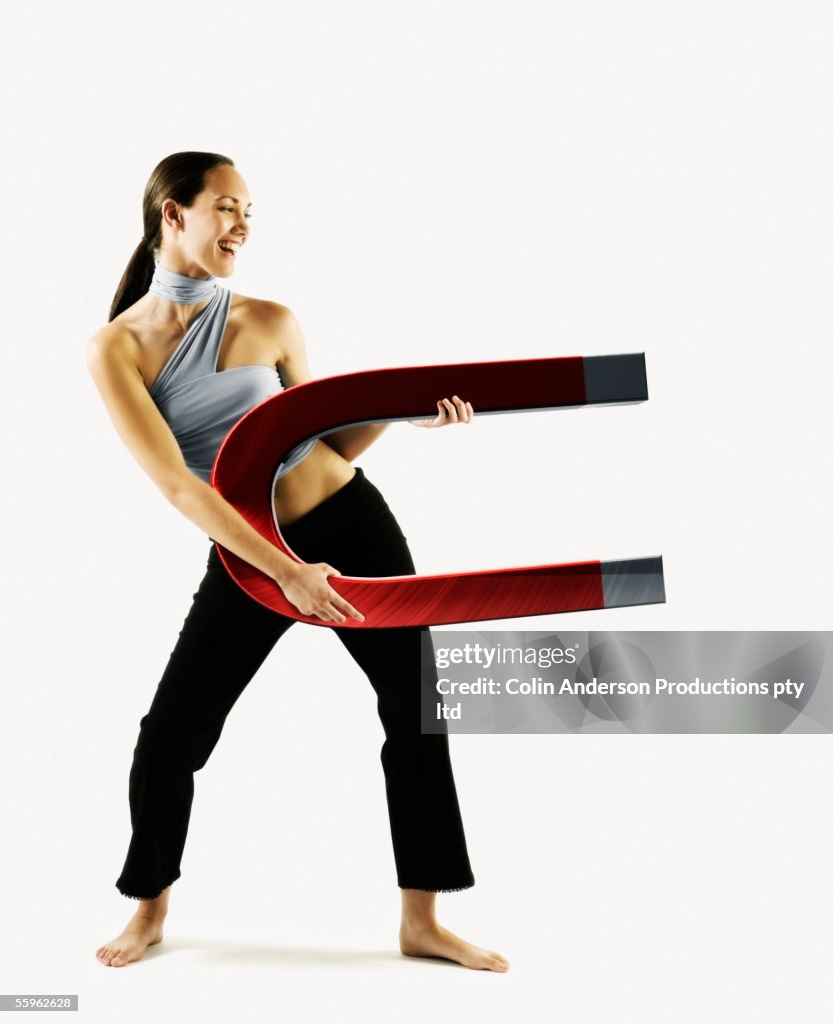 Woman holding large magnet