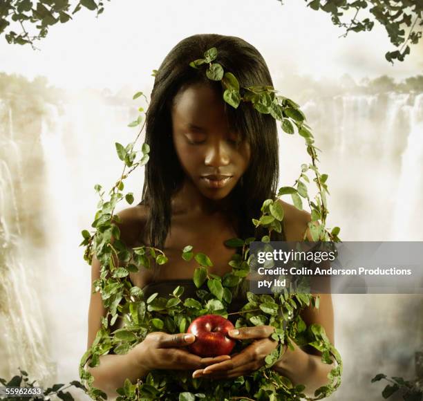 woman covered in vines holding apple - adam and eve apple stock pictures, royalty-free photos & images