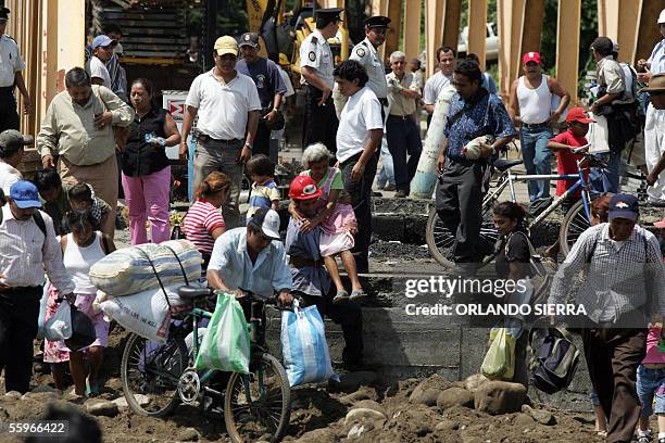 Una anciana es auxiliada por un empleado de caminos a la altura del puente Nahualate, 136 km al sur de Ciudad de Guatemala, el 19 de octubre de 2005....