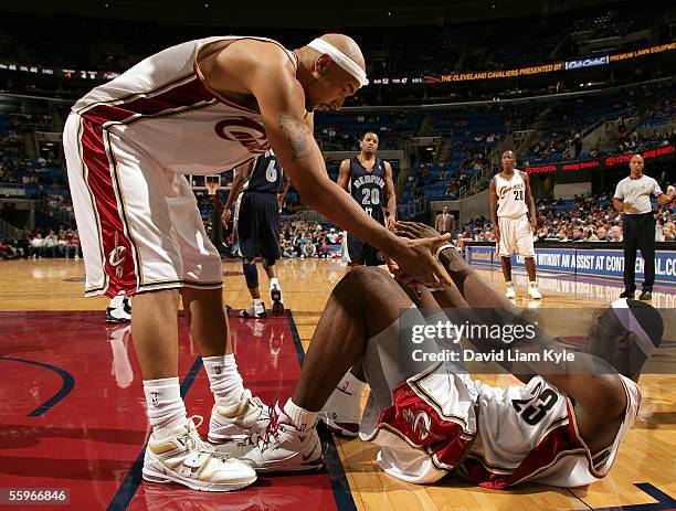 Drew Gooden of the Cleveland Cavaliers helps up teammate LeBron James after he was fouled during a preseason game against the Memphis Grizzlies at...