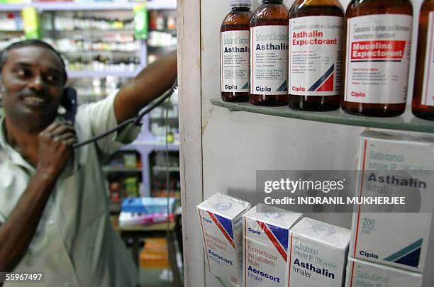 An Indian pharmacist speaks on the phone while standing near a display of Cipla products in Mumbai, 19 October 2005. India's third largest...