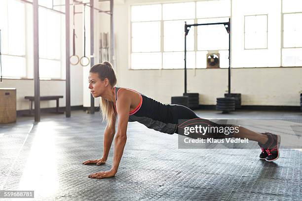 woman making pushup's in gym at sunrise - treino com o peso corporal - fotografias e filmes do acervo