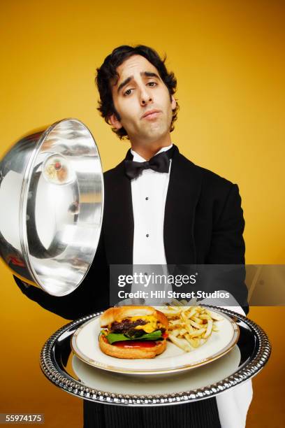 waiter delivering hamburger on silver platter - silver platter stock pictures, royalty-free photos & images