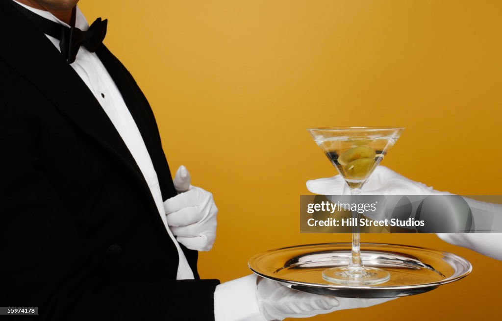 Waiter delivering martini to customer