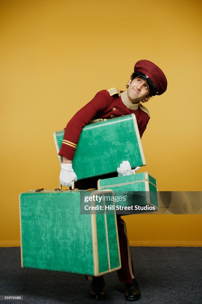 Bellboy carrying heavy luggage