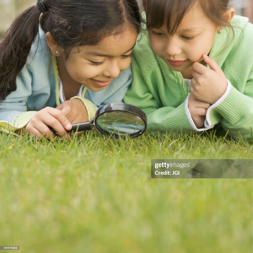 Two girls using a magnifying glass