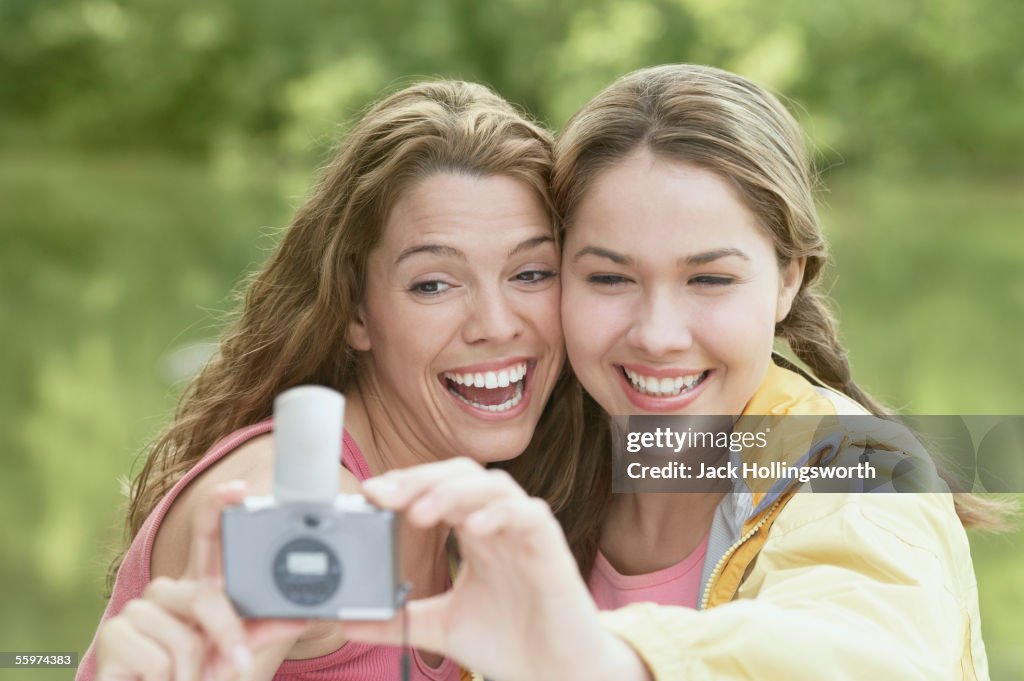 Women taking snapshots in a forest