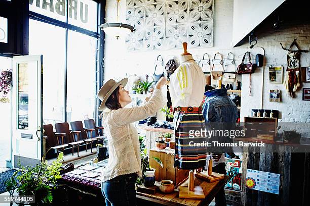 female shop owner dressing mannequin for display - vrouwelijke gestalte stockfoto's en -beelden