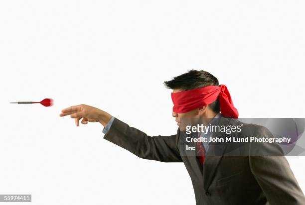blindfolded man throwing darts - blinddoek stockfoto's en -beelden