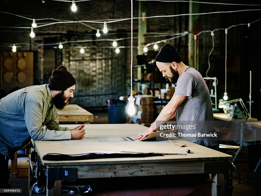 Two leatherworkers discussing product design