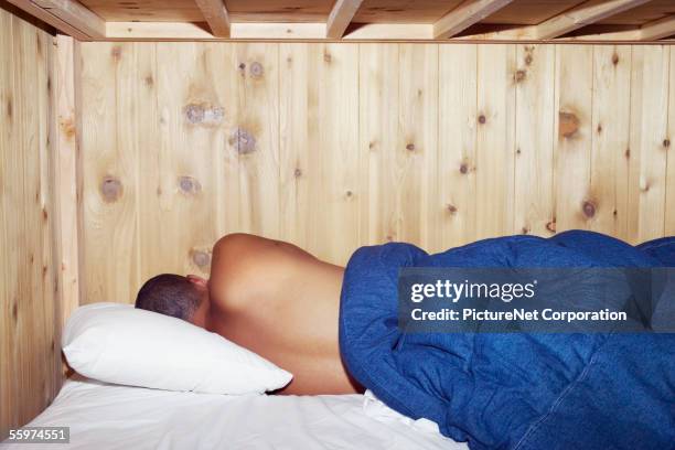 rear view of man sleeping in bunk bed - schlafsaal stock-fotos und bilder