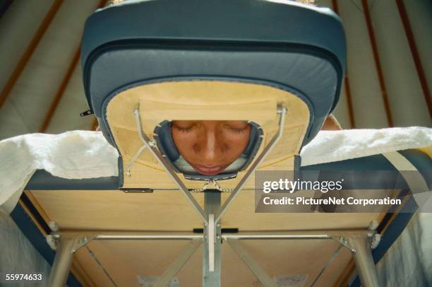 looking up at woman lying on massage table - mit dem gesicht nach unten stock-fotos und bilder
