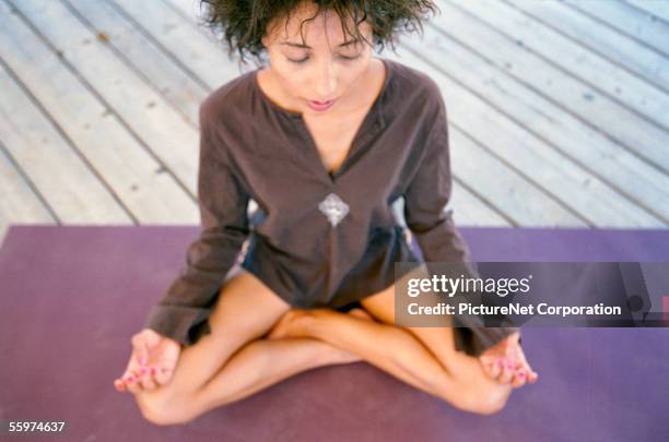 woman sitting in lotus position - new age concept photos et images de collection