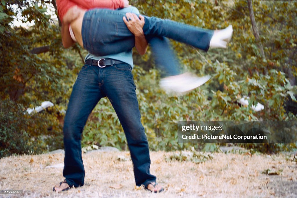 Man lifts and holds woman