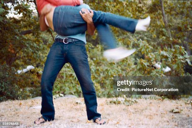 man lifts and holds woman - snatch stock pictures, royalty-free photos & images