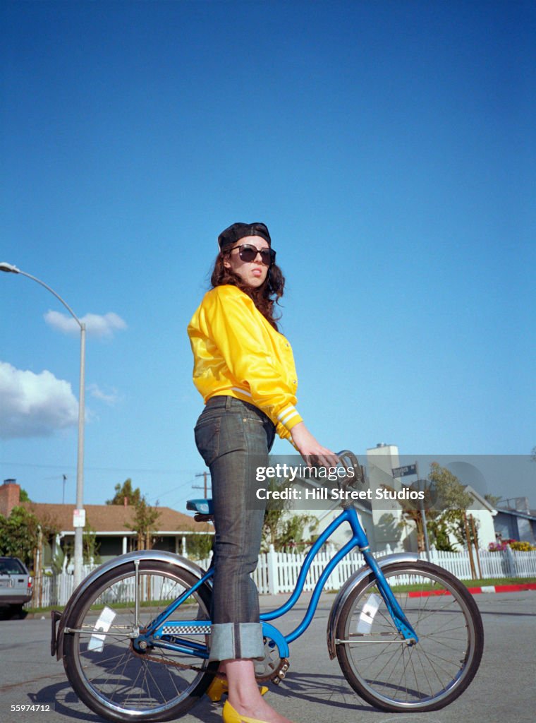 Woman standing over bicycle