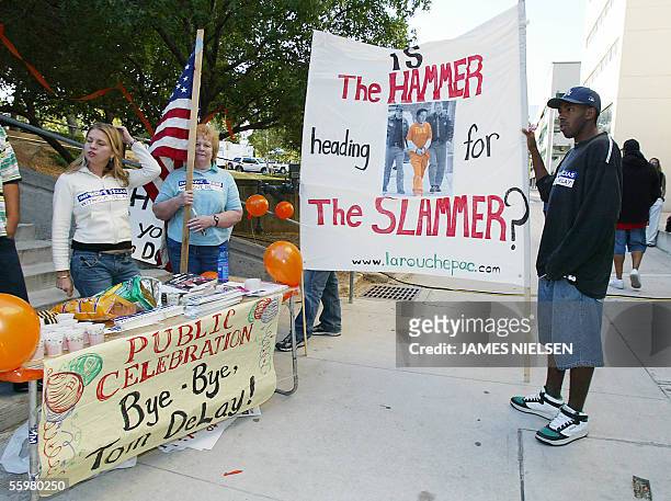 Austin, UNITED STATES: Protesters hold signs against US Representative Tom DeLay outside the Texas State Capitol in Austin, Texas, 21 October, 2005....