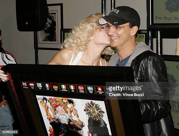 Chairman of Interscope Geffen A&M Records Jimmy Iovine presents singer Gwen Stefani with an award for her album ?Love, Angel, Music, Baby? being...