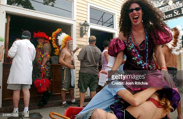 Keywester Nick Nelson laughs as friends Bradley Johnson, bottom left, and a woman who called herself Marina play with his dress during the unofficial...