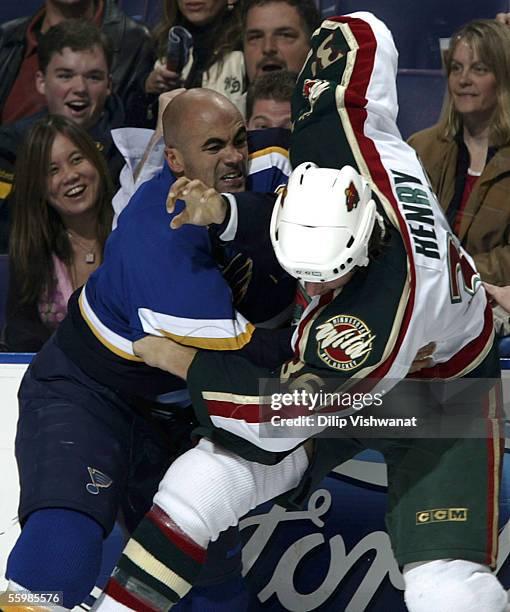 Jamal Mayers of the St. Louis Blues fights Alex Henry of the Minnesota Wild during the first period at Savvis Center on October 22, 2005 in St....