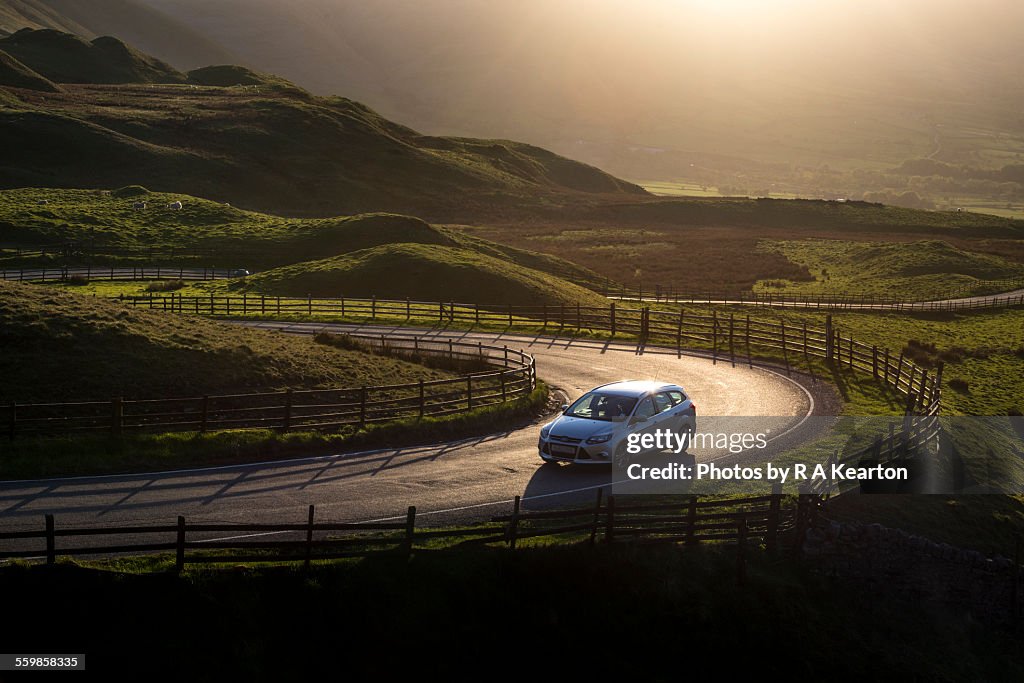 Car on a country road at sunset