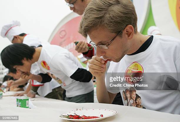 Foreigner eats chilies during a spicy-food-eating festival at the Yipintianxia Business Street, one of the venues of 2005 China International Food &...