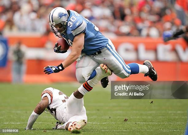Cory Schlesinger of the Detroit Lions runs with the ball as Daylon McCutcheon makes the tackle on October 23, 2005 at Cleveland Browns Stadium in...