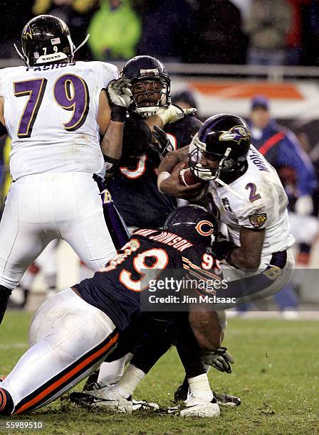 Quarterback Anthony Wright of the Baltimore Ravens is sacked by Tank Johnson of the Chicago Bears as teammate Adewale Ogunleye is blocked by Tony...