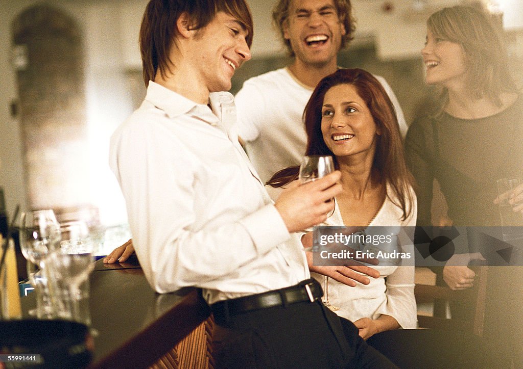 Young men and women drinking at bar