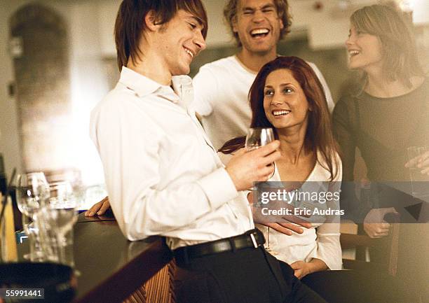 Young Men And Women Drinking At Bar, Foto de stock