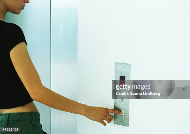woman pushing elevator button. - ongeduldig stockfoto's en -beelden