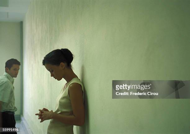 couple in front of wall. - guilt stock pictures, royalty-free photos & images