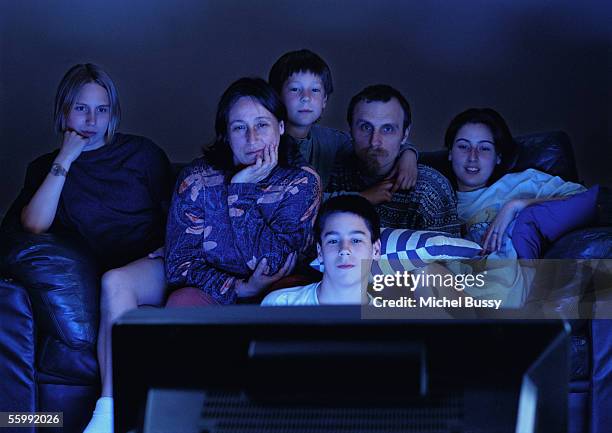 family watching television together in the dark. - tv family stockfoto's en -beelden