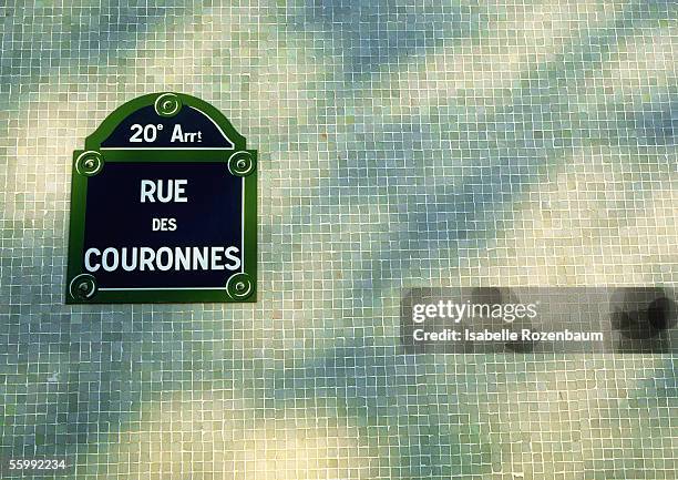 rue des couronnes street sign on tiled wall with shadows - street name sign fotografías e imágenes de stock