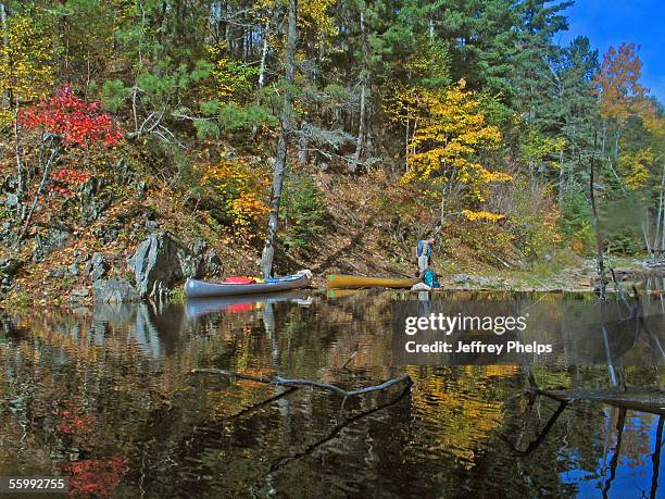 Canoeists rest along Mudro Lake in the Boundary Waters Canoe Area October 7, 2005 near Ely, Minnesota. The two man group was hunting for Moose in the...
