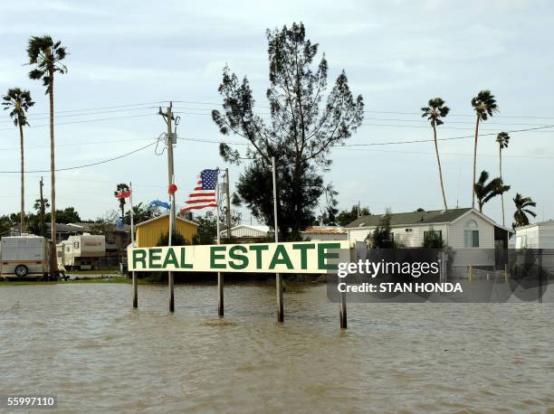 Real estate business sign stands in several feet of water on a flooded street 24 October 2005 in the aftermath of hurricane Wilma in Everglades City,...